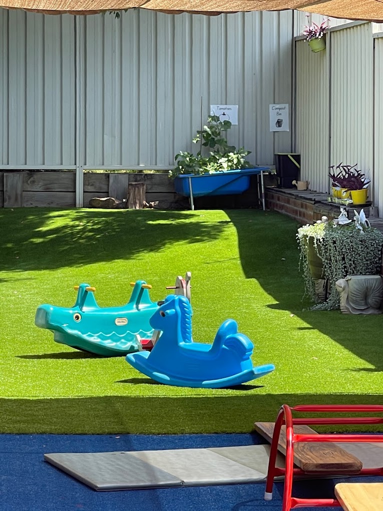 childcare outdoor area with toys on grass
